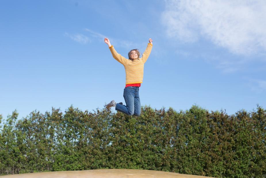 购物工具：爆发照片显示一个女人在外面的空中跳跃